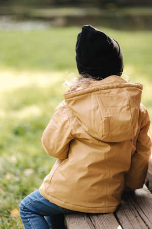 Little female kid eating chocolate pancake outdoor. Autumn moodの写真素材