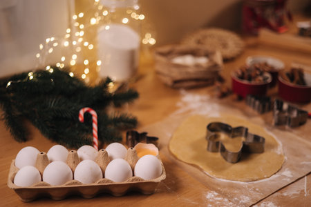Home bakery, cooking traditional festive sweets. Cutting cookies of raw gingerbread dough on wooden table. New Year celebration traditions. Christmas moodの写真素材