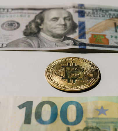 Digital cryptocurrency gold bitcoin lying between US Dollar and Euro banknotes. Difference between...