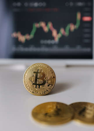 Gold bitcoin crypto currency on background of tablet with stock diagram. Investment in virtual money. Cryptocurrency conceptの写真素材