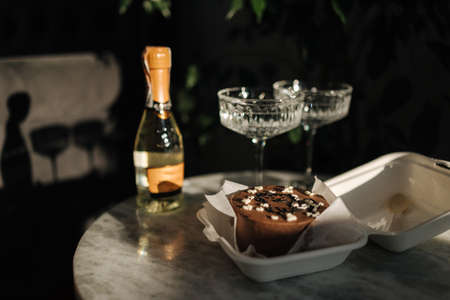 Chocolate bento cake with little champagne for a little birthday party. Exquisite champagne glasses on luxury marble table. Cake for two person. Birthday conceptの写真素材