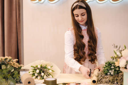 Female make spring bouquet. Gardeners in the flower shop make bouquet. Lifestyle flower shop. Beautiful flower compositionの写真素材