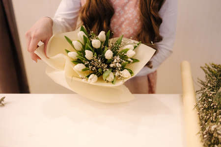 Flower shop make bouquet for a holiday. Family flowers business. Beautiful flower composition. Detail. Close upの写真素材