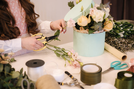 Flower shop make bouquet for a holiday. Family flowers business. Beautiful flower composition....