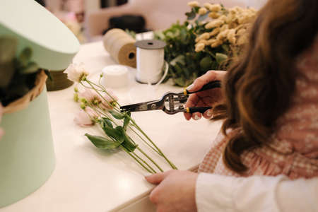 Flower shop make bouquet for a holiday. Family flowers business. Beautiful flower composition. Detail. Close upの写真素材