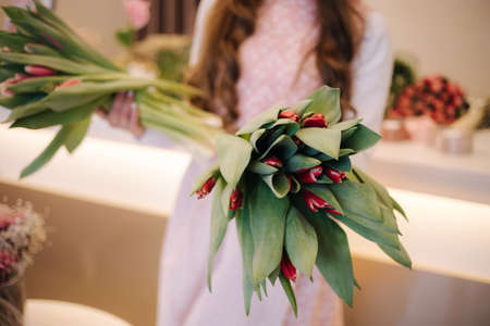 Woman make spring bouquet. Female florist hold bouquet of spring flowers. Beautiful flower composition. Fresh tulipsの写真素材