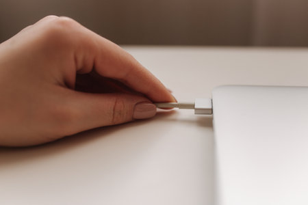 Human hand holding the power plug of pc notebook. Laptop power. Chargerの写真素材