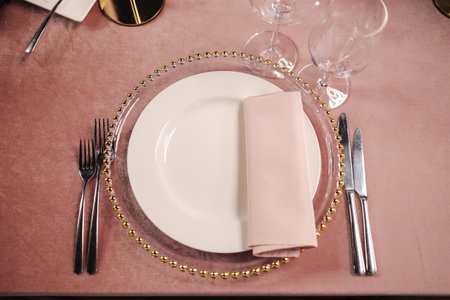 Top view of plate on the table. Cutlery on pink tablecloth