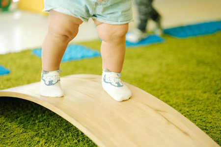 Little girl balancing on a board, trainig of the vestibular apparatus. Close-up