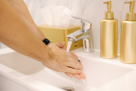 First person view of man washing his hand under the water tap. Hygiene concept hand detail. Close-up of human hands. Keep clean conceptの写真素材
