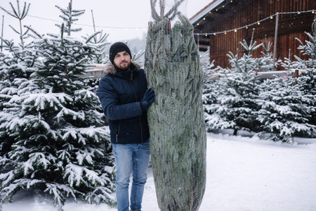 Young man stand by Christmas tree. Big tree for big family. Happy winter holidays