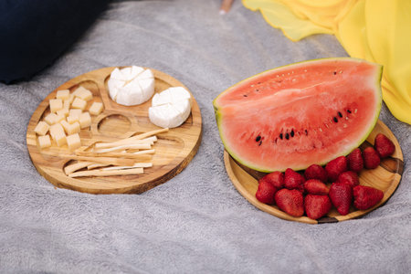 Food on wooden table outside. Picnic concept. Sliced pumpkin and strawberry. Different kind of...