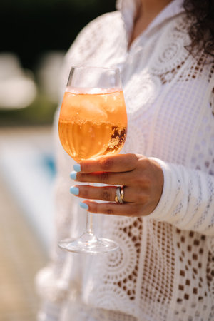 Close-up of female hold orange alkohol drinkの写真素材
