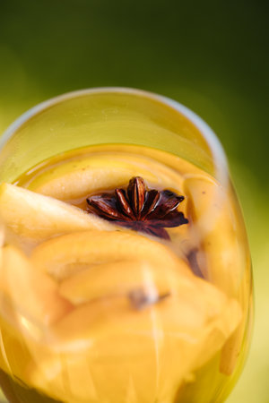 Hot mulled wine in a glass with chopped fruits and star aniseの写真素材