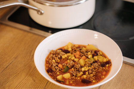 Finished traditional Mexican dish in a plate near the saucepan. Spicy foodの写真素材