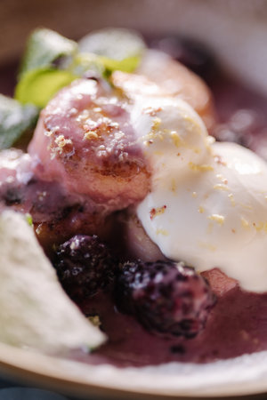 Macro photo of curd fritters in cream-berry sauce with bilberry. Cheesecake decorated sour cream and mint.の写真素材