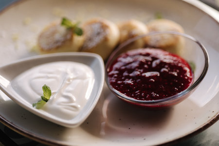 Freshly baked cottage cheese pancakes with strawberries jam and sour cream. Healthy food, mint leafの写真素材