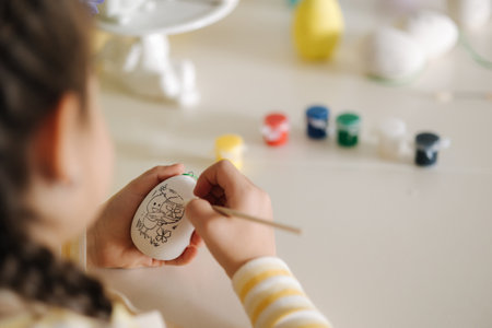 First person view of little girl painting easter eggの写真素材