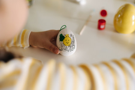 First person view of little girl painting easter eggの写真素材