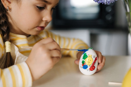 Macro photo of little girl growing easter eggs on kitchenの写真素材