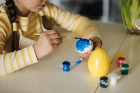Macro photo of little girl growing easter eggs on kitchen. Yellow and blue colour. Ukrainian symbolicの写真素材