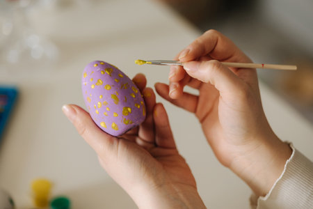 First person view pf woman painting Easter eggs using brush and yellow paint. Spring holidays.の写真素材