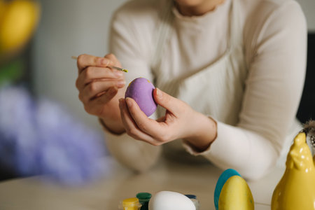 Middle selection of young woman painting Easter eggs in the kitchen. Spring holidays.の写真素材