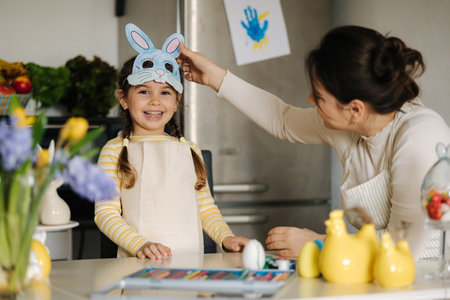 Mom take off the Easter bunny mask from her daughters face to see her beautiful smileの写真素材