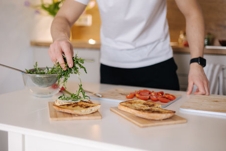Close-up of man put organic arugula on bruschetta. Vegan foodの写真素材