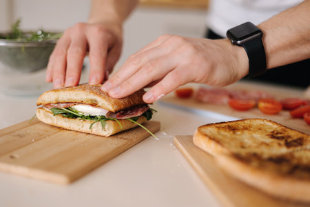 Man presses the top of the sandwich to show juicinessの写真素材