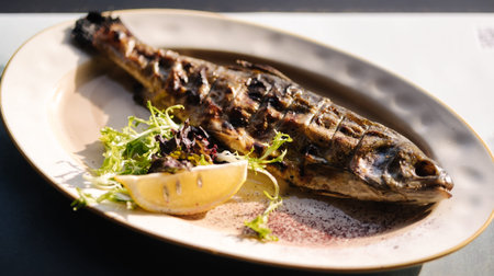 Baked seabass fish in the oven served with slice of lemon and pea sprouts