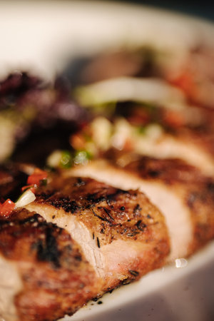 Macro photo of tasty baked pork tenderloin and a side dish of potatoes on summer terrace. Outdoor dinnerの写真素材