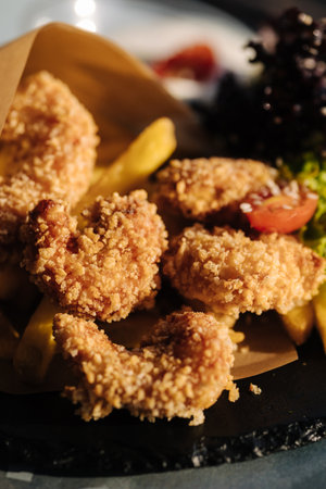 Fried shrimp in breadcrumbs served in food paper on plateの写真素材