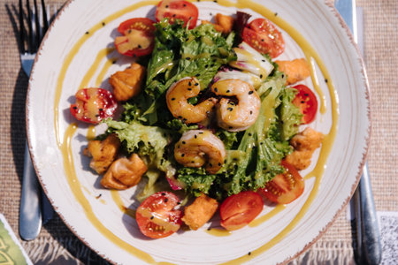 Top view of warm salad with shrimps and salmon, sauce and parmesan on top. Healthy food outdoorの写真素材