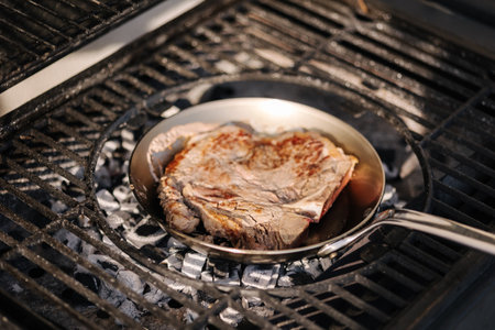 Tasty T-bone Steak on pan frying on BBQ grill. Close-up of beef steak. Grilled meatの写真素材