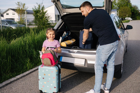 Father help daughter loading to the trunk with luggage before traveling while mom packs her luggageの写真素材