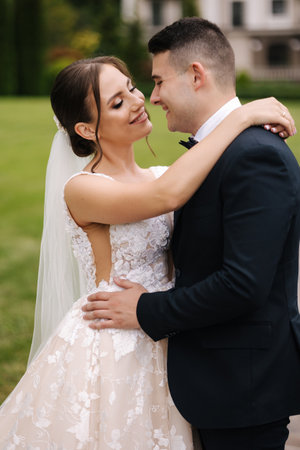 Close-up portrait of beautiful wedding couple walking outdoors. Groom and bride in the parkの写真素材