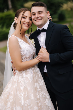 Groom and bride look into camera and smile. Portrait of beautiful wedding coupleの写真素材