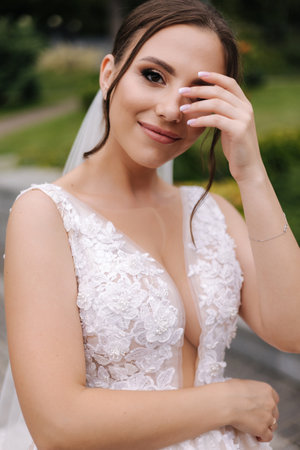 Portrait of gorgeous bride in wedding dress standing outdoors. Beautiful bride in elegant dressの写真素材