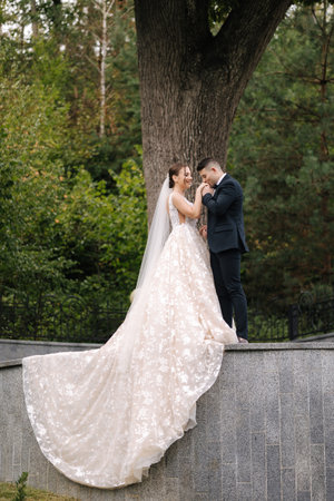 Beautiful wedding couple stand by the big tree. Gorgeous wedding dressの写真素材