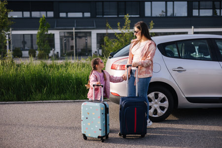 Mom and daughter stand near the car with their suitcases and waiting for the trip. Family journeyの写真素材