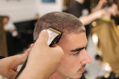 Side view of male client sitting in barber shop. Hair cut in salonの写真素材