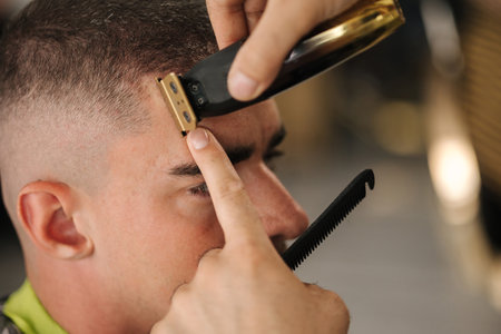 Close-up of barber use trimer for making modern hair cut. Barber shopの写真素材