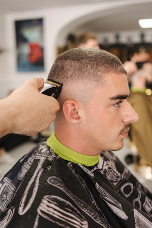 Side view of male client sitting in barber shop. Hair cut in salonの写真素材