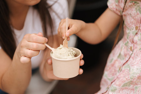 Close-up of mom and daughter eating ice cream. Delicious sweetsの写真素材