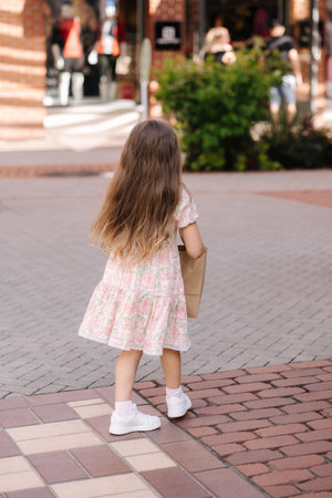 Back view of cute little girl on shopping. Portrait of adorable kid with shopping bagsの写真素材