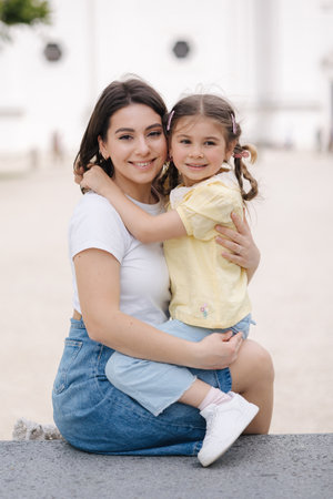 Adorable little daughter hug her mom and smile. Beautiful happy familyの写真素材