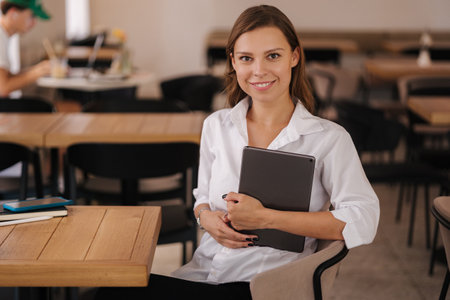 Portrait of business lady hold digital tablet. Female sitting in cafe. Freelancer concept. Financial managerの写真素材