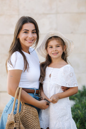Portrait of mom and daughter smile and look into camera. Stylish girls. Happy family conceptの写真素材