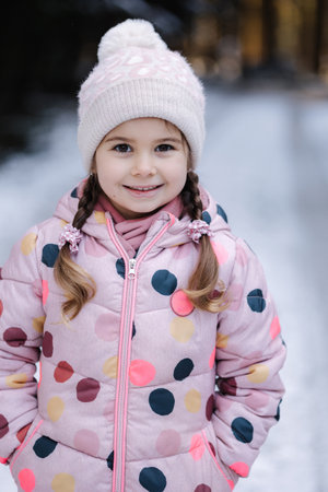 Close-up portrait of beautiful little girl in winter forest. Christmas moodの写真素材